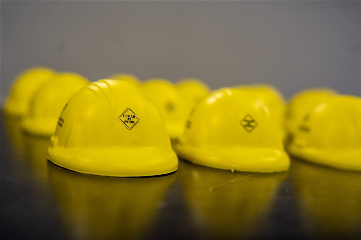 Yellow REHAB AT WORK branded miniature hard hats
